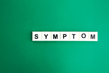 stethoscope and letters of the alphabet with the word Symptom. medical and health concepts