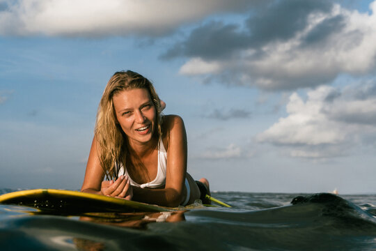 Young woman surfing at sunset.