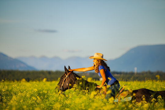 Girl laughing on horseback through a canola field in Montana