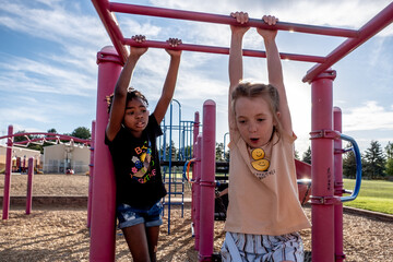 School aged children playing on monkey bars