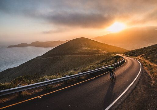 cyclist on road at sunset, Golden Gate, Marin Headlands, California