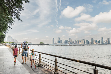 family of three walking in new york city, hudson river