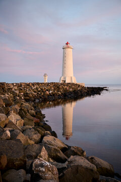 Lighthouse on coast of sea in sunset