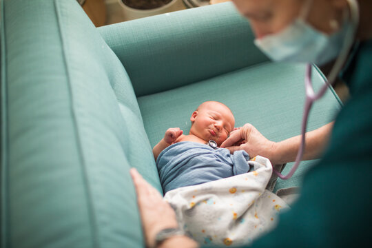 Midwife, doctor checking newborn baby's heartbeat, vitals