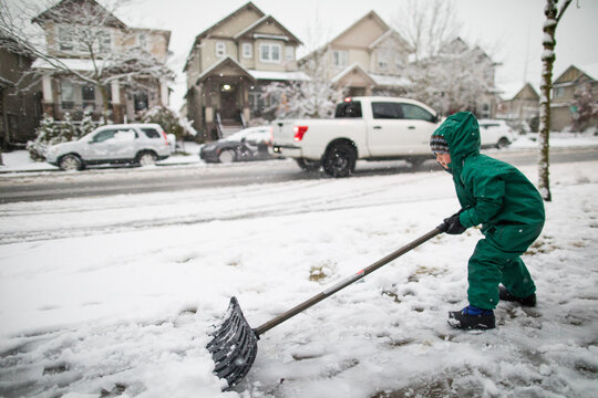 strong young man shovels snow off the sidewalk