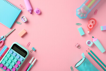 Back to school concept. Frame made of stylish school supplies on pastel pink background. Flat lay, top view calculator, paper notebook, pencil case, sharpeners, markers, pens