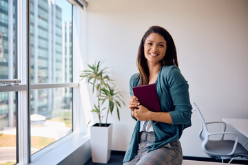 Portrait of happy female entrepreneur in office looking at camera.