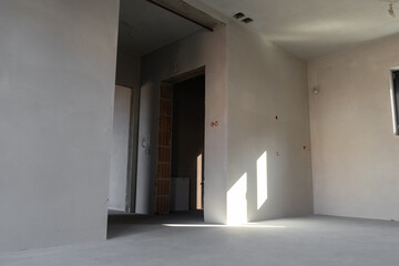 Interior of new apartment in shell and core state or developer standard. Inside empty rooms before renovation. Interior spaces left unfinished, without any fixtures or finishes.