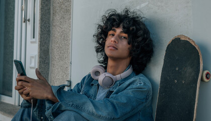 teenager with headphones and phone alone and sad in the street