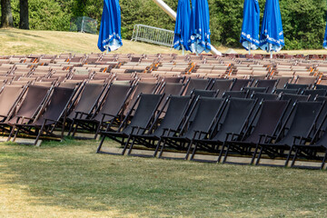 Many rows of empty lawn chairs in park