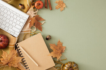 Naklejka na ściany i meble Make your workspace autumnal. Top view arrangement of keyboard, copybook, pen, warm plaid, pumpkins, cinnamon sticks, autumn leaves on olive background with empty space for advert or text