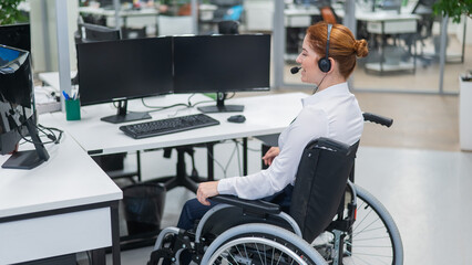 Red-haired caucasian woman in a wheelchair talking on a headset. Female call center worker at her...