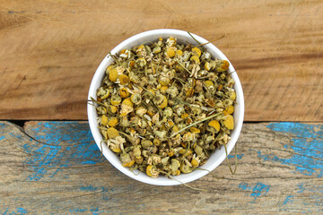 Dried Chamomile flowers in a bowl top view 