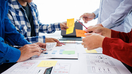 Close-up ux developers and ui designers use augmented reality to brainstorm on mobile app interface...
