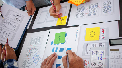Close-up ux developers and ui designers use augmented reality to brainstorm on mobile app interface...