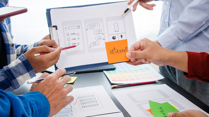 Close-up ux developers and ui designers use augmented reality to brainstorm on mobile app interface...