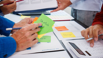 Close-up ux developers and ui designers use augmented reality to brainstorm on mobile app interface wireframe designs on modern office desks. Creative digital development office