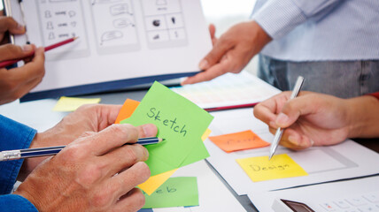 Close-up ux developers and ui designers use augmented reality to brainstorm on mobile app interface...
