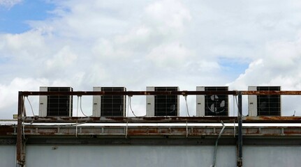 A set air conditioner on the roof of an industrial building with blue sky.