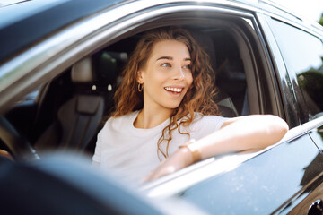 Stylish woman driving a car. The traveler is the driver. Automobile travel. Sharing a car....