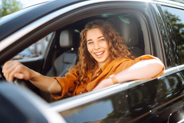 Stylish woman driving a car. The traveler is the driver. Automobile travel. Sharing a car. Lifestyle concept.