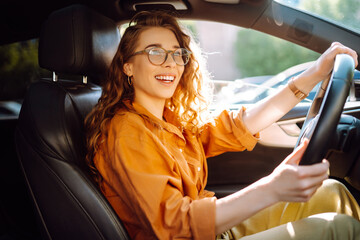 Stylish woman driving a car. The traveler is the driver. Automobile travel. Sharing a car....