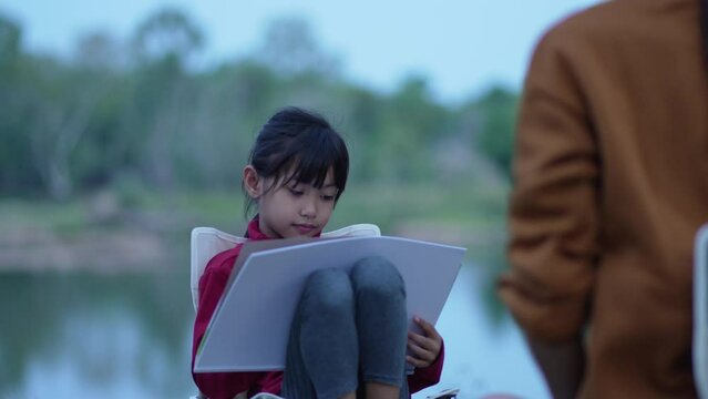 The daughter was drawing a picture for her mother at the poolside of the park1.