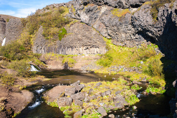 Naklejka na ściany i meble Gjáin tranquil, scenic valley with many small waterfalls, ponds and lava rocks, plus volcano views.