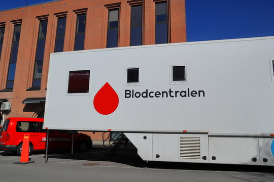 Blood bus trailer. Free for the public to donate blood. Medical healthcare service. Swedish text Blodcentralen. Symbol of red blood drop against a white background.