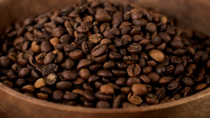 Obraz premium Coffee beans in wooden bowl, close up