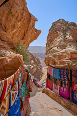 A market with colorful tapestries along a path through the mountains in the city of Petra, Jordan