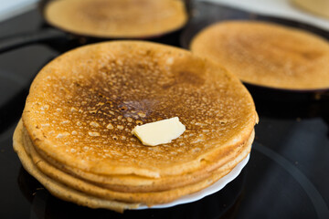 Process of baking pancakes in pans on kitchen stove. stack of hot pancakes