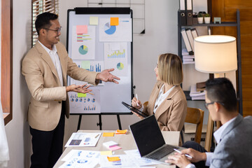 Group of confident business people point to graphs and charts to analyze market data, balance sheet, account, net profit to plan new sales strategies to increase production capacity.	