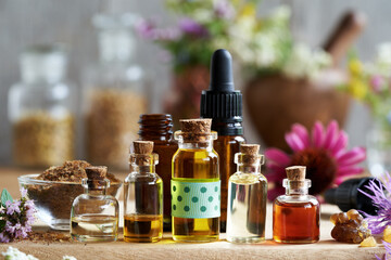 Obraz na płótnie Canvas Selection of essential oils with myrrh, frankincense, herbs and flowers