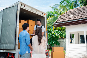 Asian Couple check while unloading boxes and furniture from a pickup truck to a new house with service cargo two men movers worker in uniform lifting boxes. concept of Home moving and delivery.