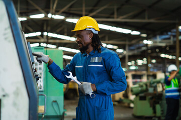 Portrait American male worker working with industrial machines in heavy industry. American engineer working on steel machine.