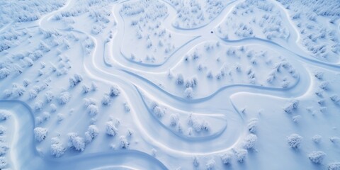Drone view of snow-covered countryside, bosque nevado con muchos caminos zigzagueantes 