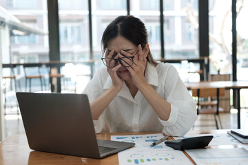 Tired and upset young businesswoman feeling exhausted from working in the office too long.