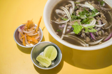 Pho is Vietnamese soup dish consisting of broth, rice noodles, herbs, and beef pork chicken meat. Typically served with scallion, onion and cilantro (coriander leaves), bean sprouts, lime, chili oil.