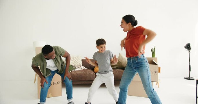 African American man and son repeat dance moves after woman