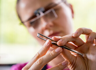 Young female jeweler making jewelry in workshop