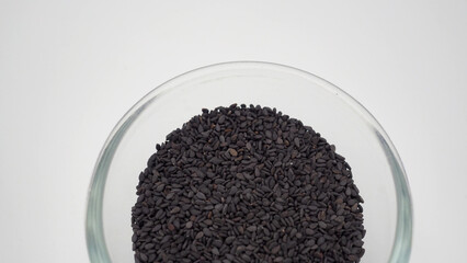 Black sesame seeds in a bowl on white background.It is asian food.