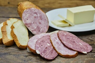 Smoked or dried sausage surrounded by bread and butter. Breakfast products. Meat production