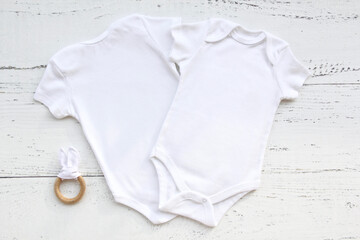 Baby bodysuit front and back template on white wooden background.