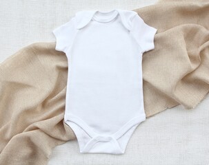 Baby wear rompers onesie flatlay on a linen fabric. Girl or boy bodysuit mockup. Copy space for...