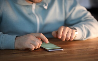 Close-up of male hands surfing internet on modern smartphone. Businessman searching information via special cellphone app. Social networks and modern technology concept
