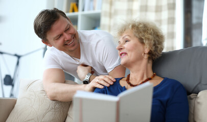 Portrait of happy cheerful relatives smiling at home. Smiling adult man having fun with aged mom....