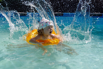 Fototapeta premium Happy child playing in swimming pool. Summer vacation concept