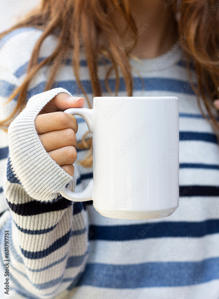 Wall mural Girl is holding white mug in hands. Blank 15 oz ceramic cup. mug mockup with copy space - Wall murals