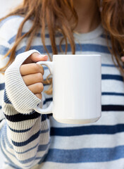 Girl is holding white mug in hands. Blank 15 oz ceramic cup. mug mockup with copy space